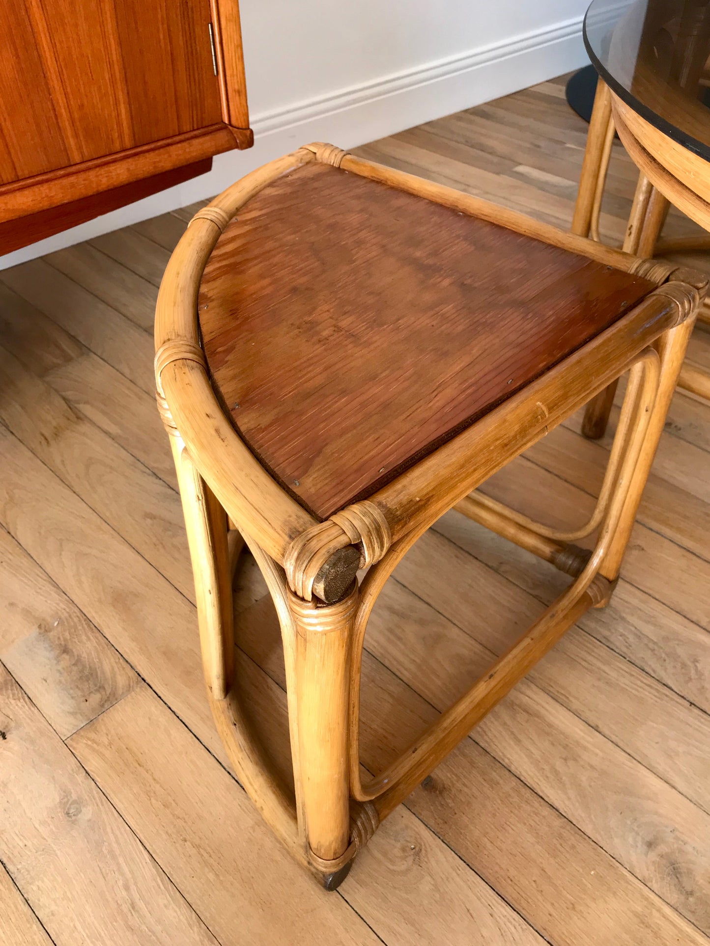 Ensemble en rotin design composé d'une table basse ronde avec plateau en verre fumé et 4 tabourets années 60