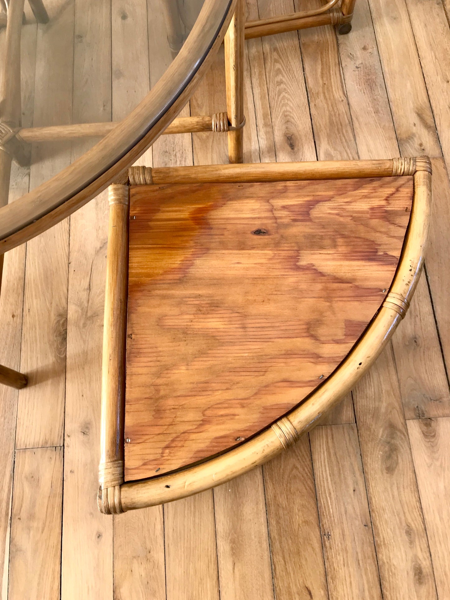 Ensemble en rotin design composé d'une table basse ronde avec plateau en verre fumé et 4 tabourets années 60