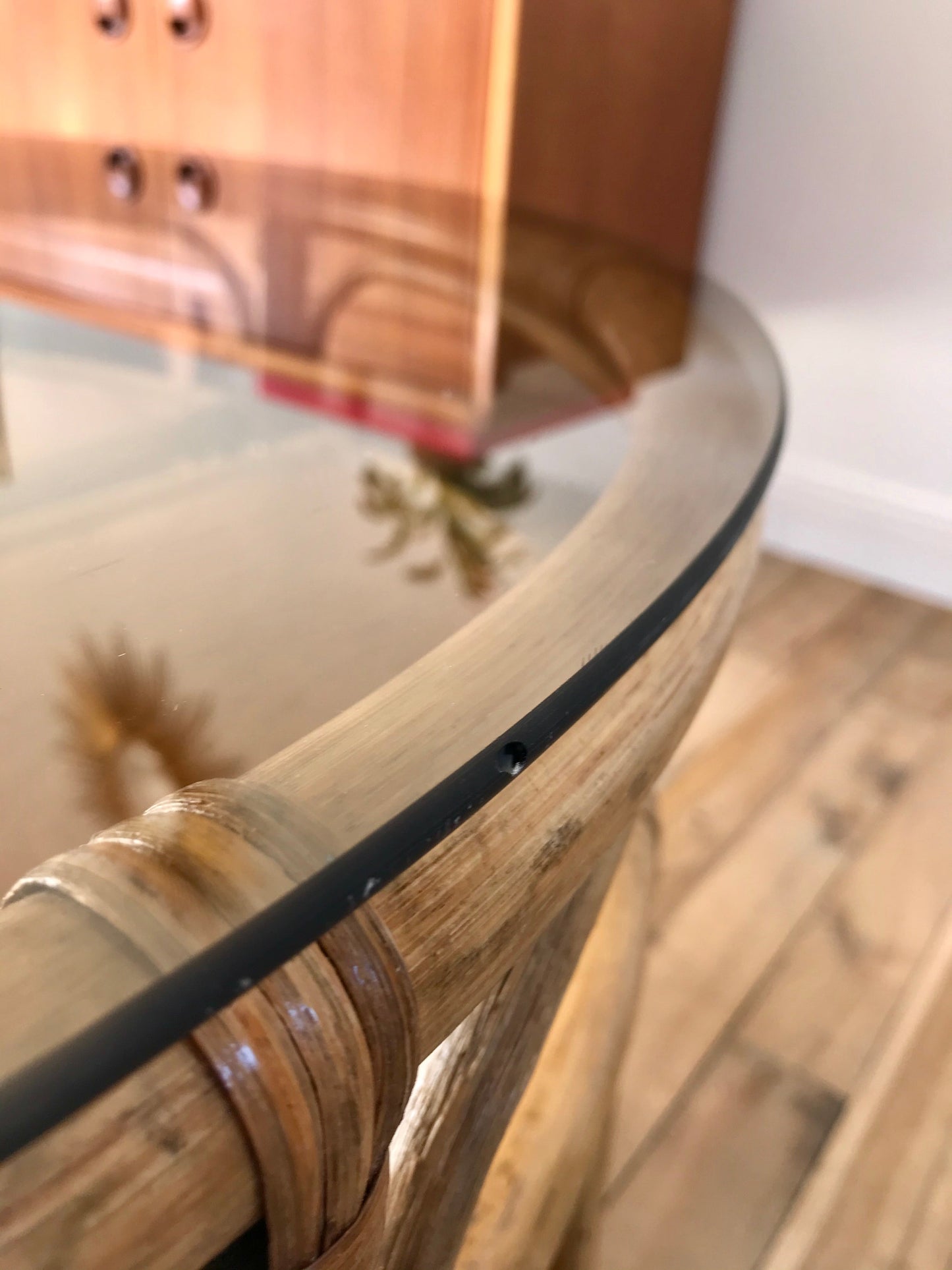 Ensemble en rotin design composé d'une table basse ronde avec plateau en verre fumé et 4 tabourets années 60