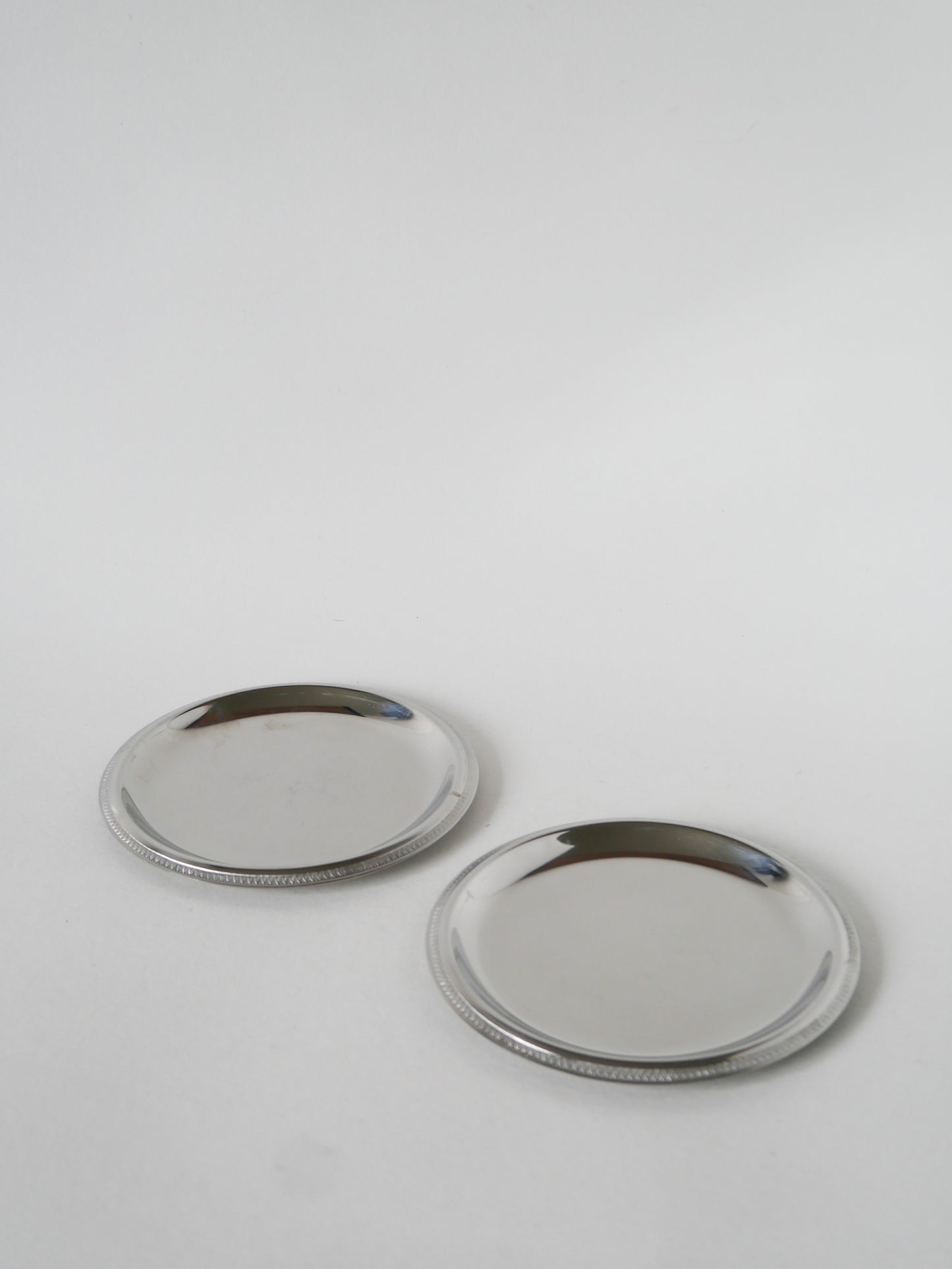 Paire de dessous de bouteilles en inox, 1970 - 14 cm